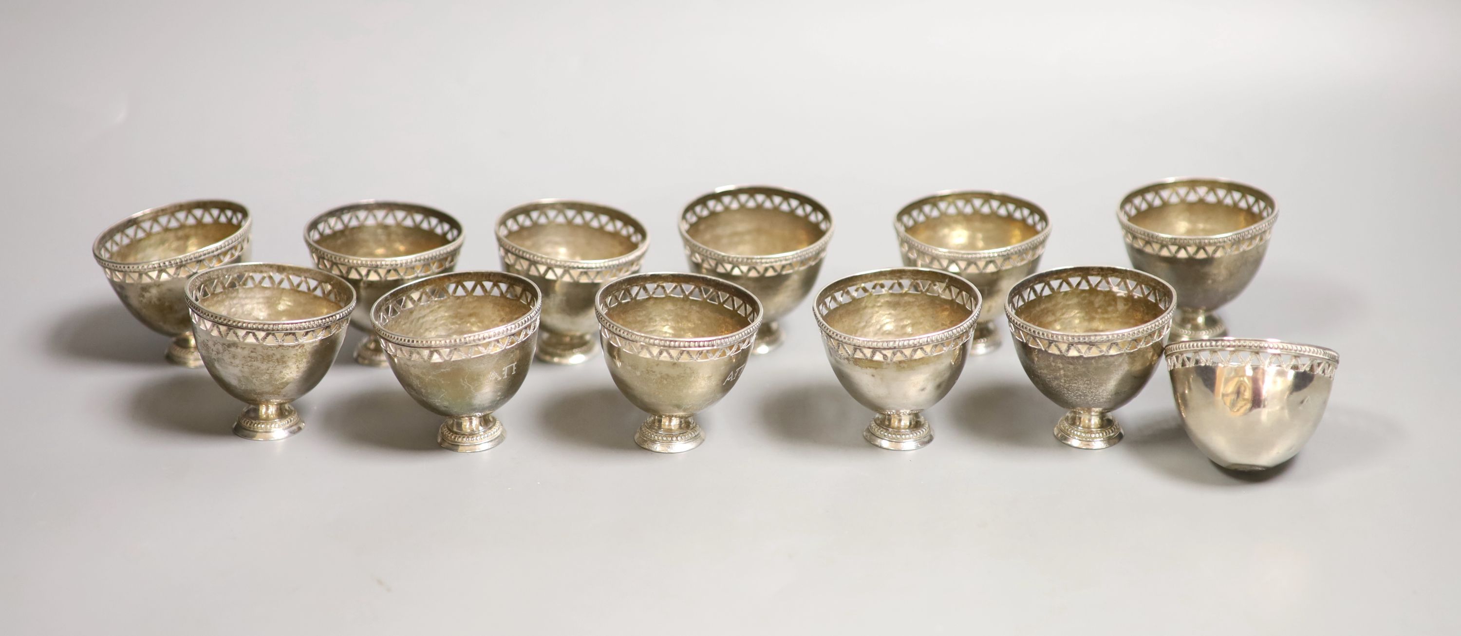 A set of twelve pierced small white metal footed cups